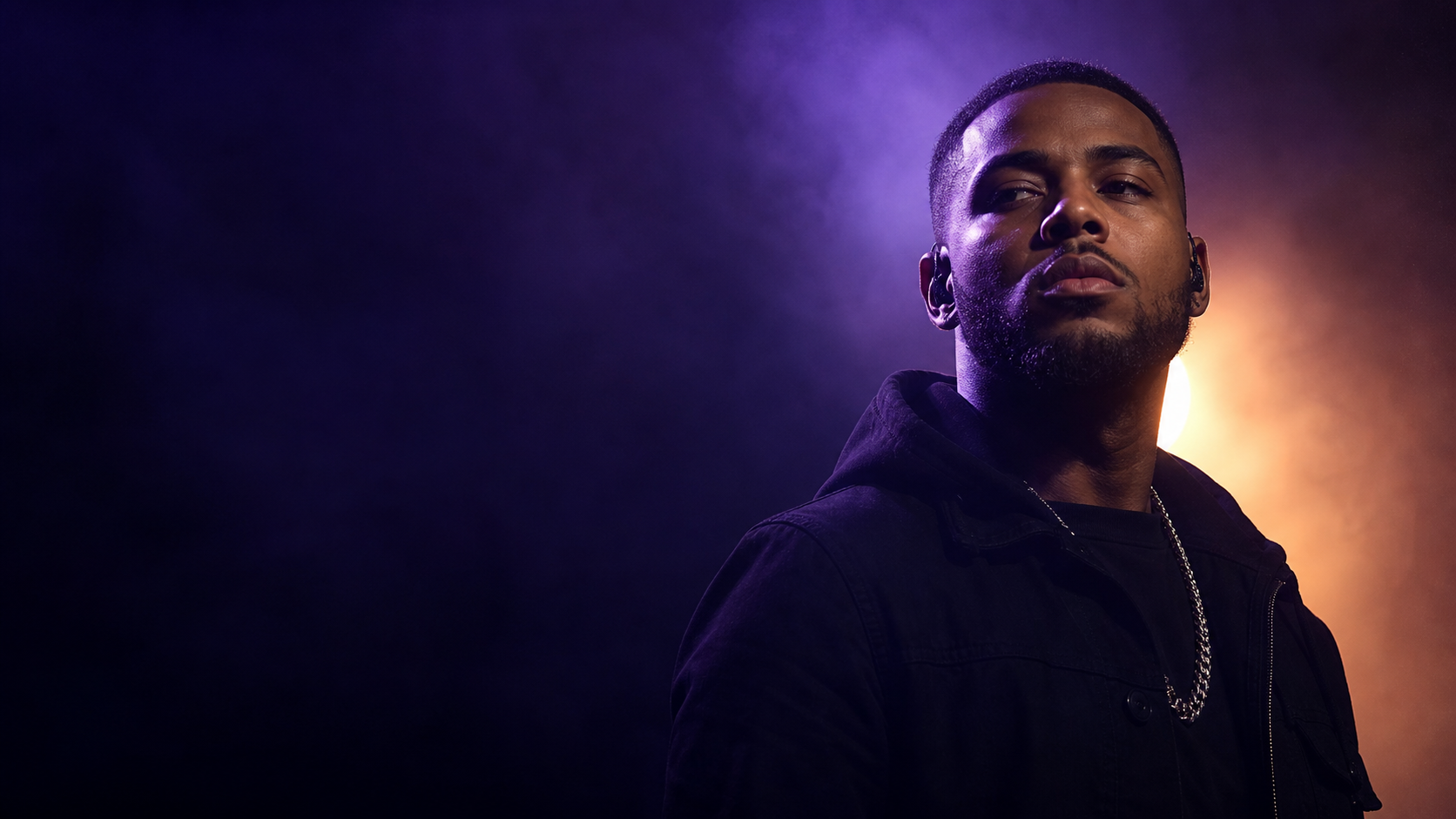 Rap artist silhouetted in violet haze and amber light